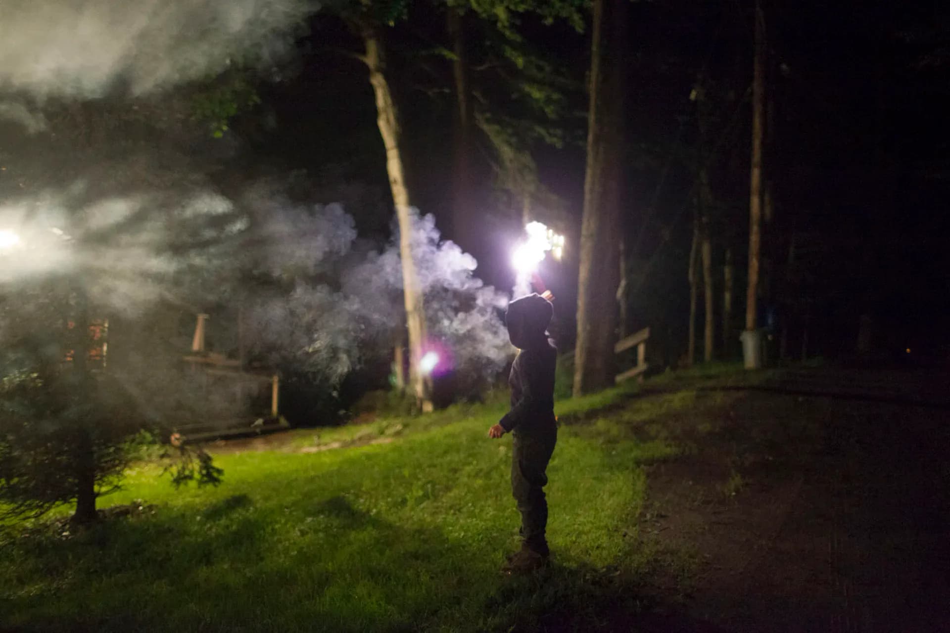 Child standing in autumn forest looking into the woods
