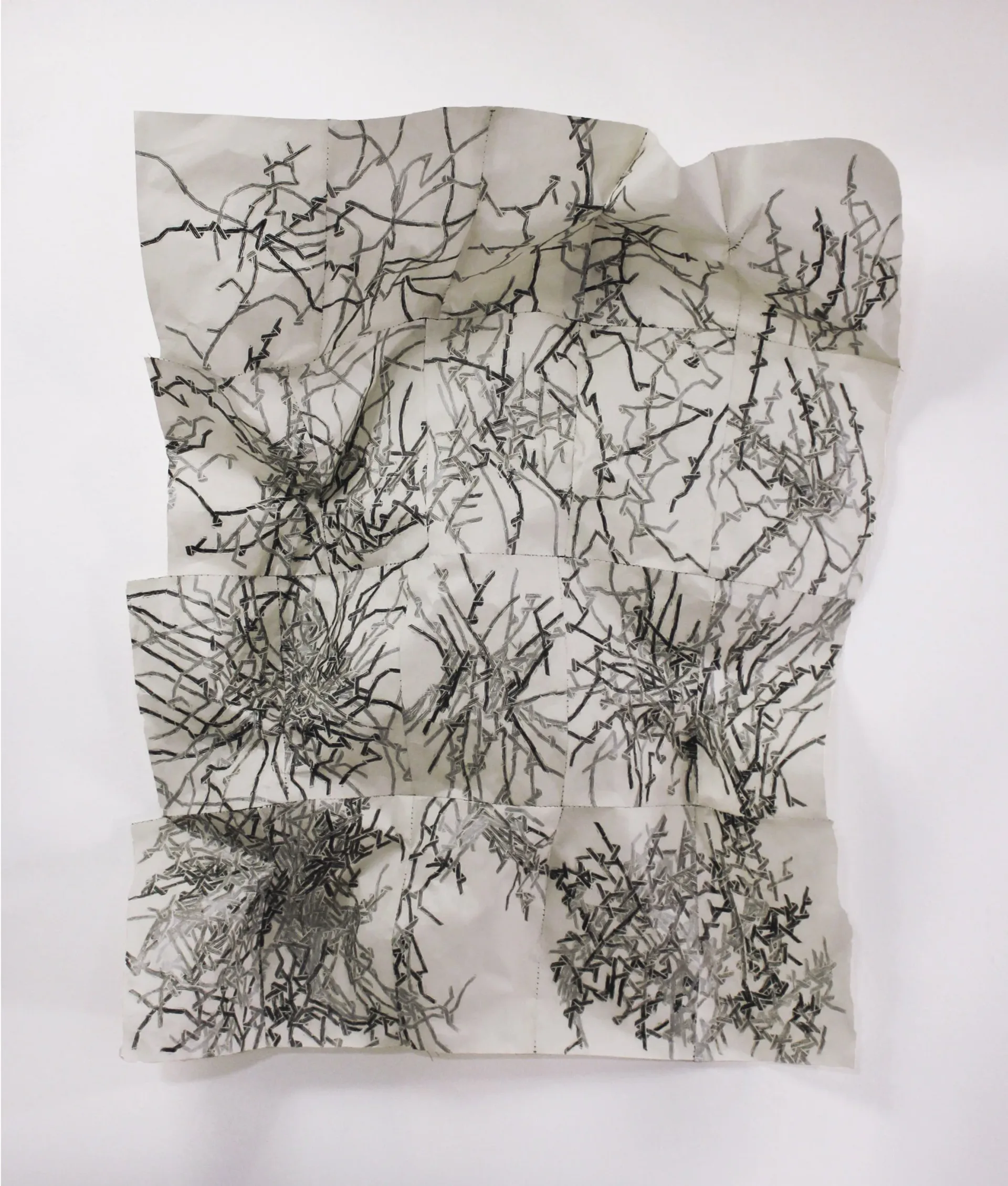 Large-scale abstract printed textile work with dense branching black and grey mark-making on crumpled white fabric panels