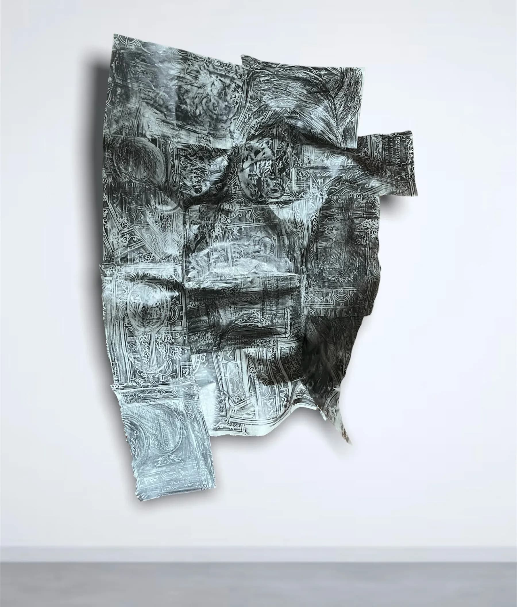 Large printed fabric work with dense baroque imagery hung dramatically on a gallery wall column