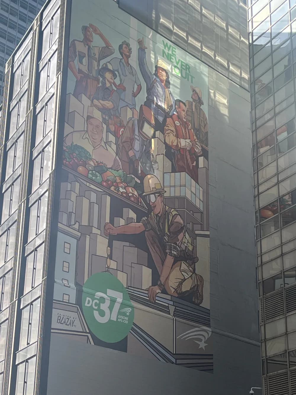 Large-scale mural depicting stylized figures in warm tones ascending brick architecture, with a green DC37 union logo at bottom.