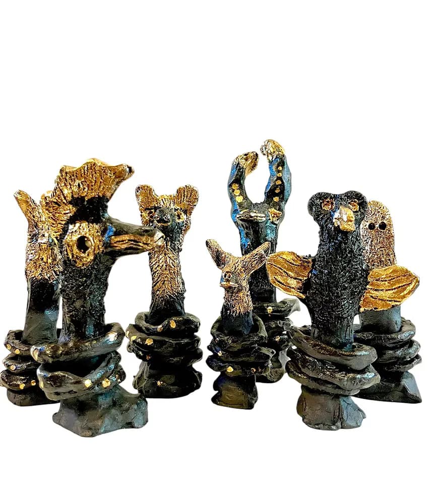 Group of dark ceramic figurative sculptures with gold detailing