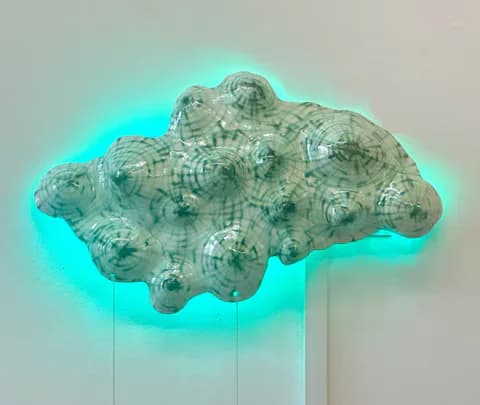 Ceramic wall-mounted sculpture with lumpy organic form and red LED backlighting with stitched details