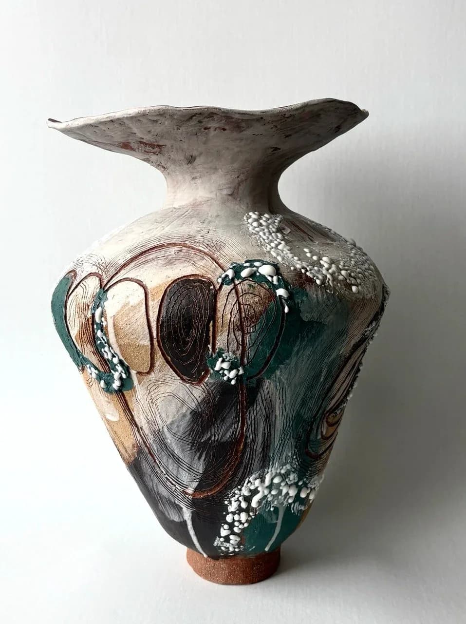 Ceramic vessel with wide flared rim, swirling teal and white glaze with concentric ring motifs