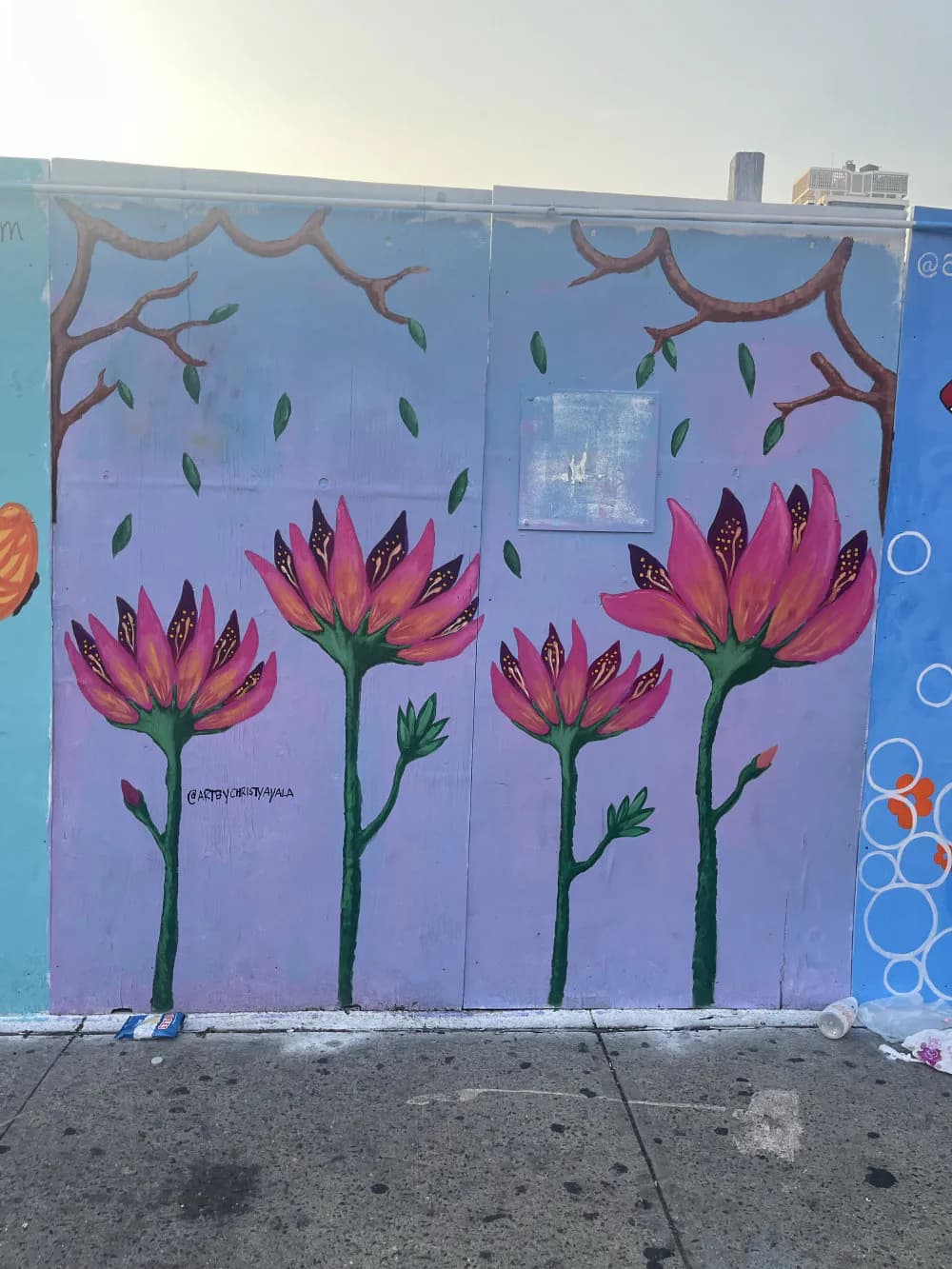 Mural of pink and red flowers with green stems and leaves against a lavender background with branching brown lines and falling leaves.