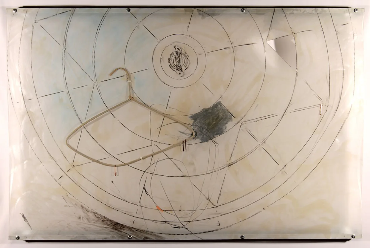 Mixed media assemblage with concentric circles, coat hanger, and found objects on translucent panel