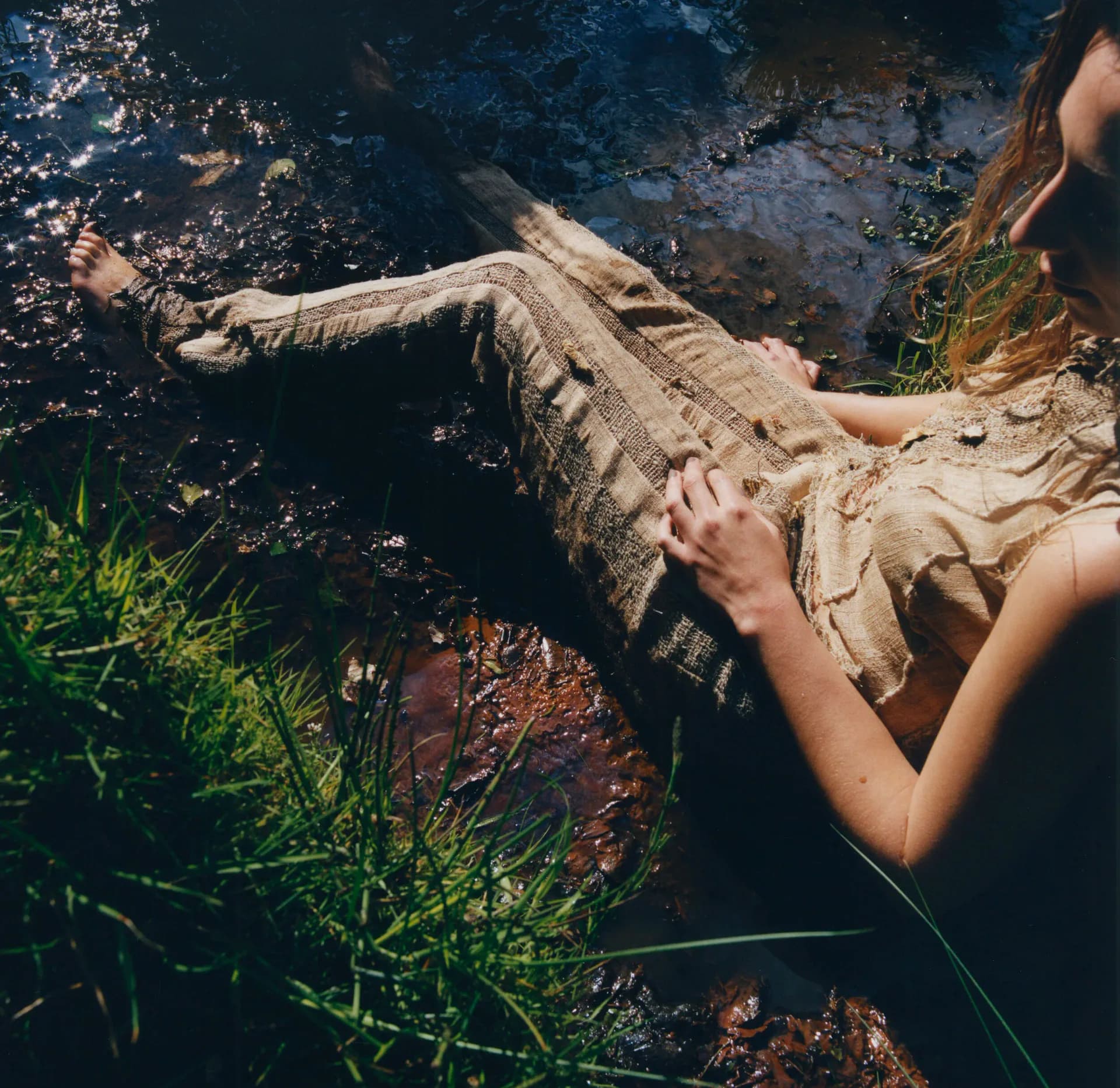 Flat lay of biofabricated textile pieces with orange mushrooms, lace and organic materials