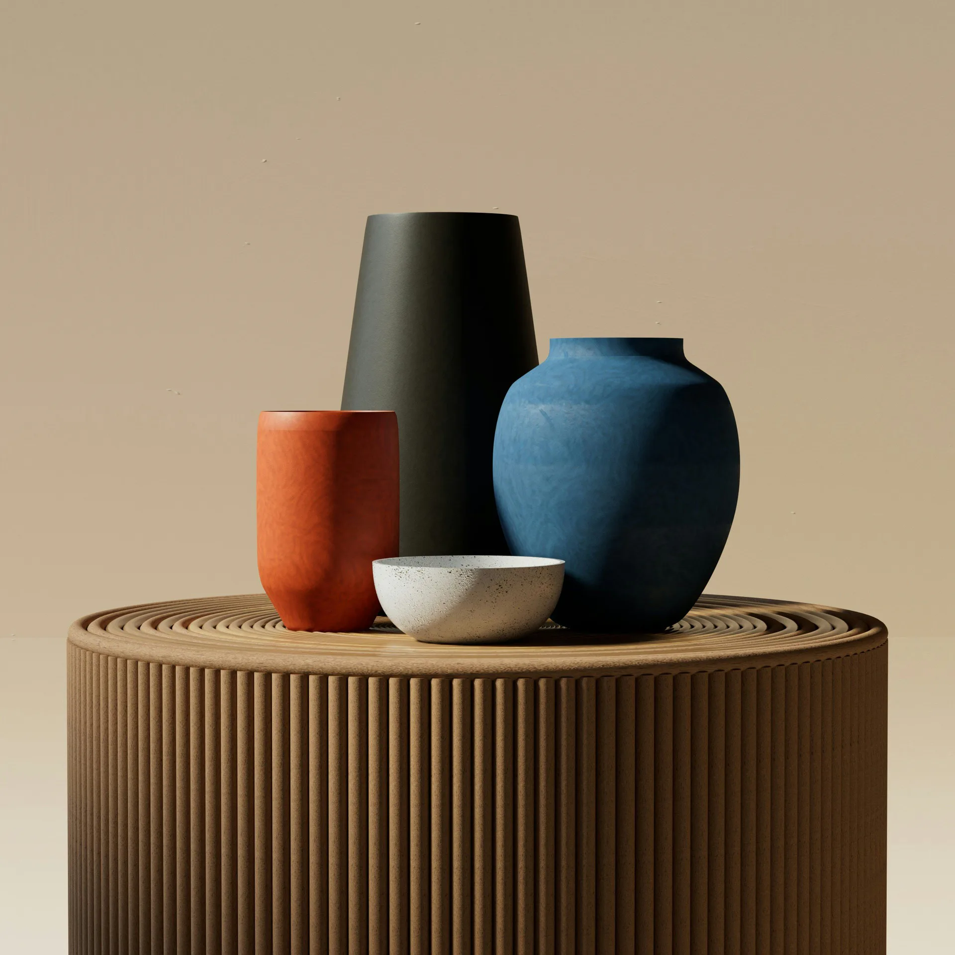 Still life arrangement of ceramic vessels—an orange cylinder, black tapered form, blue bulbous vase, and white bowl—on a ribbed beige pedestal base.