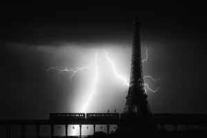 Black and white photograph of lightning striking near the Eiffel Tower at night