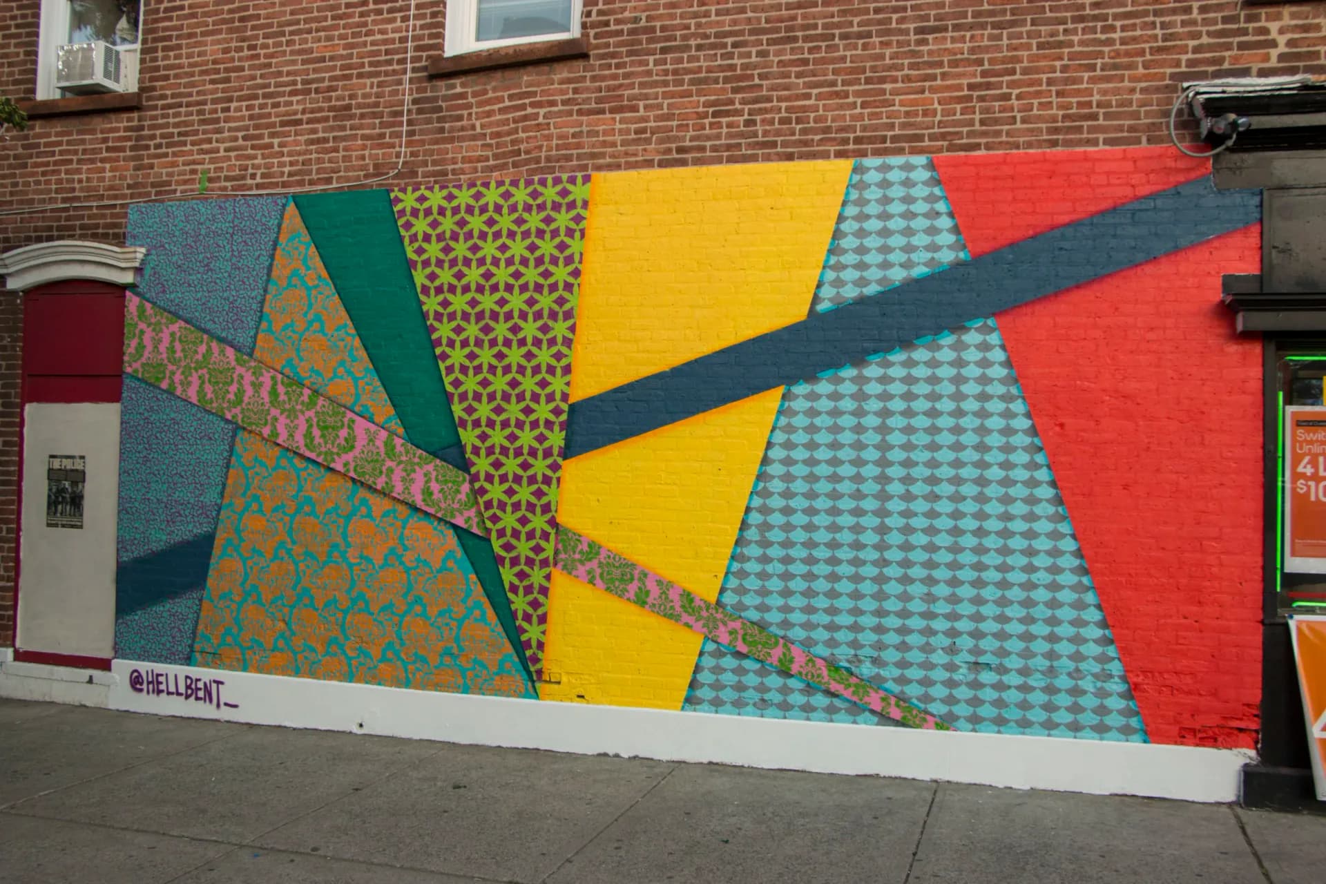 Large-scale aerial view of colorful patterned mural covering entire building facade in Albany