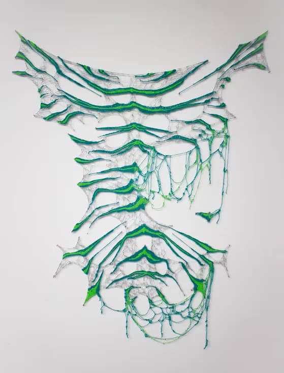 Large-scale wall-mounted fiber sculpture with green crochet and delicate net forms
