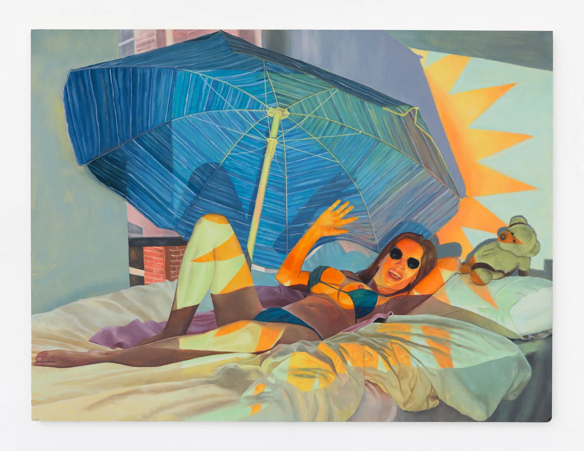 Woman reclining on a bed under a large blue beach umbrella with surreal orange sunburst shapes in the background