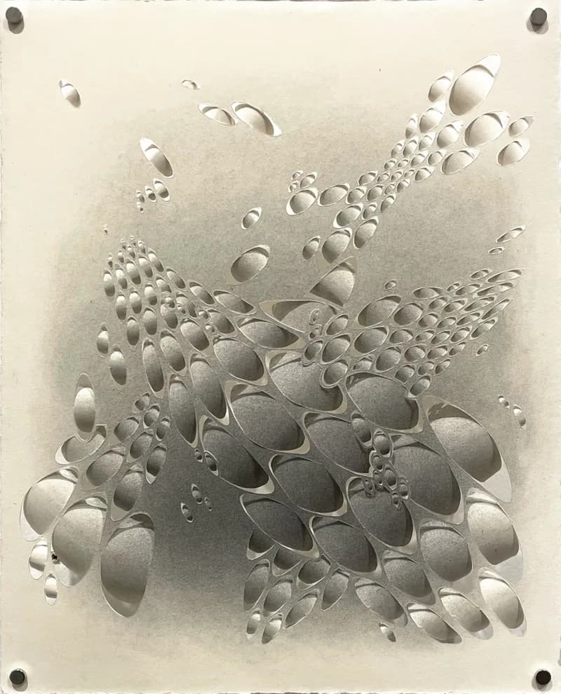 Cut paper artwork with hundreds of oval perforations creating organic clustered forms on graphite-shaded paper