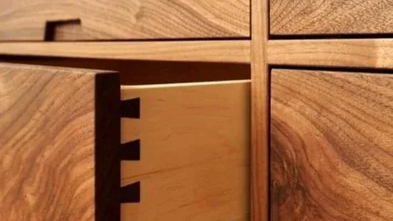 Close-up detail of walnut dresser drawers with dovetail joinery