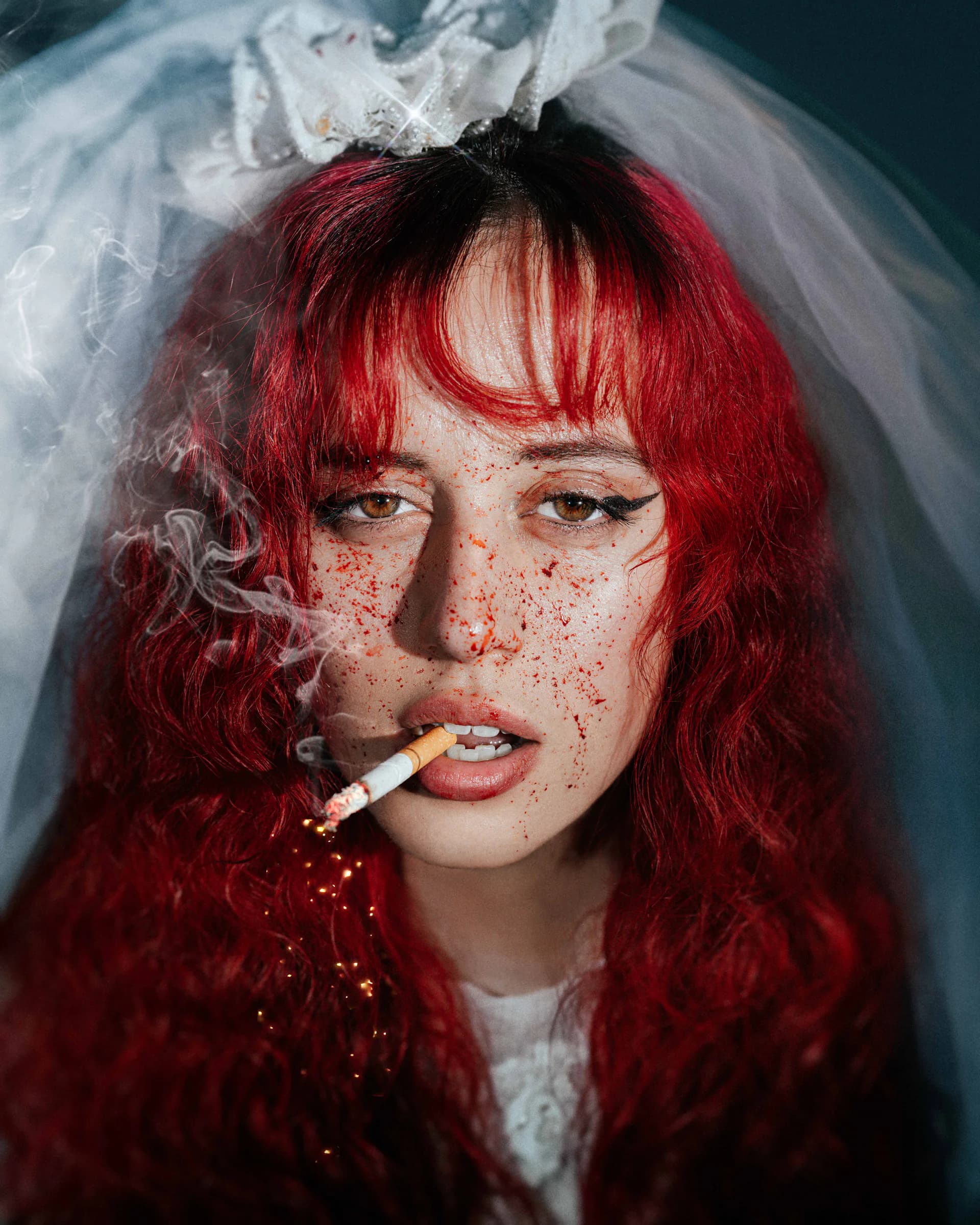 Red-haired bride with blood splatter, cigarette and veil — intense editorial portrait