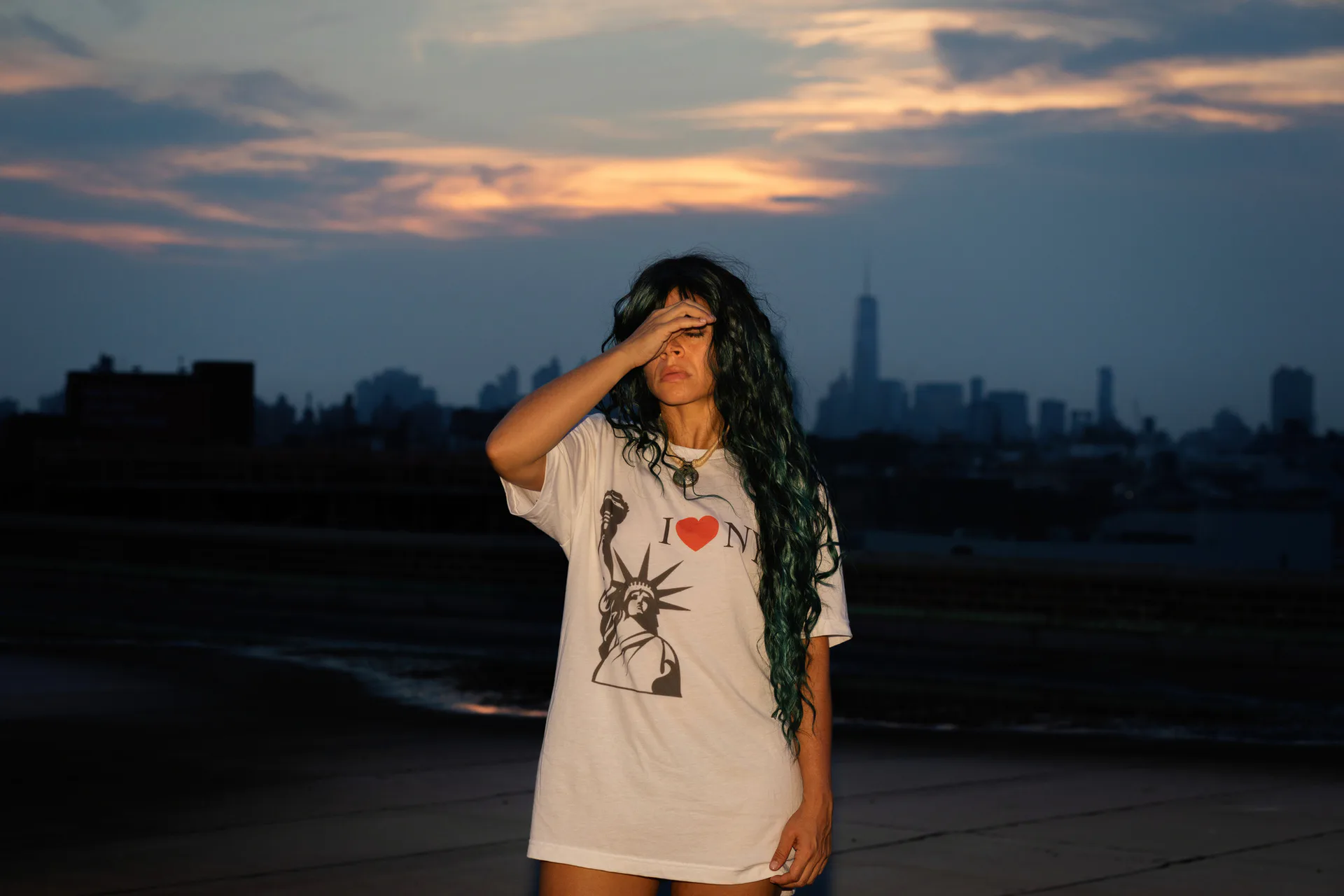 Black and white photograph of two women on ornate sofa with headless suit standing behind them