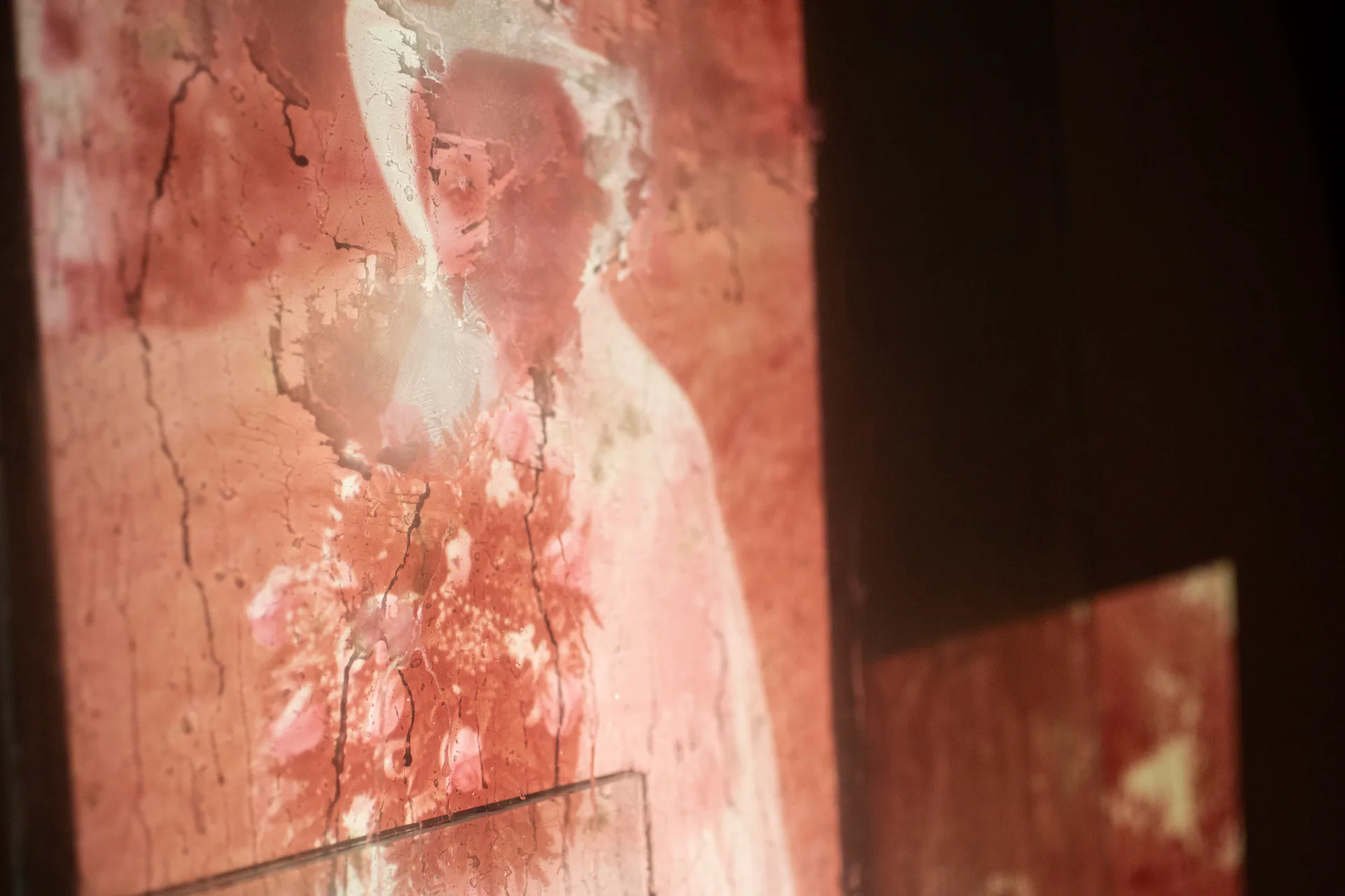 Installation with projected wedding photographs onto circular disc and wall, glass sphere and mirrors on dark floor