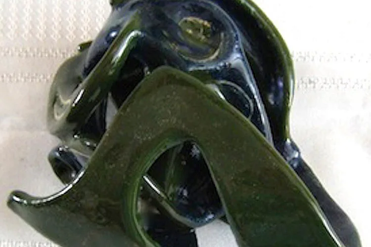 Nancy Quigley sculpture: dark blue and olive-green curved abstract forms, possibly ceramic or cast material, with smooth organic surfaces.