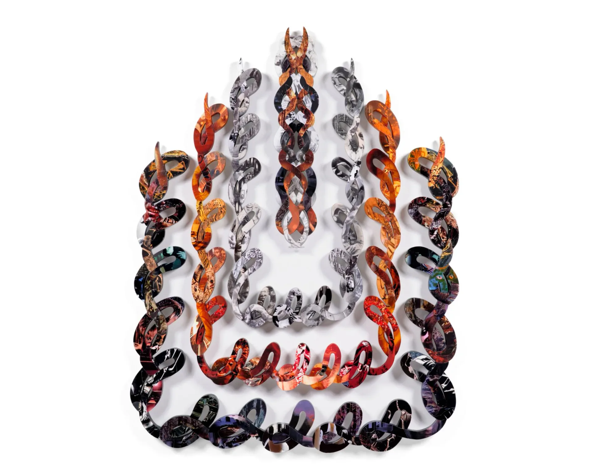 Large-scale wall sculpture composed of interlocking S-curve chain links covered in photographic collage imagery in orange, red, black and silver tones, arranged in a flame-like crown shape