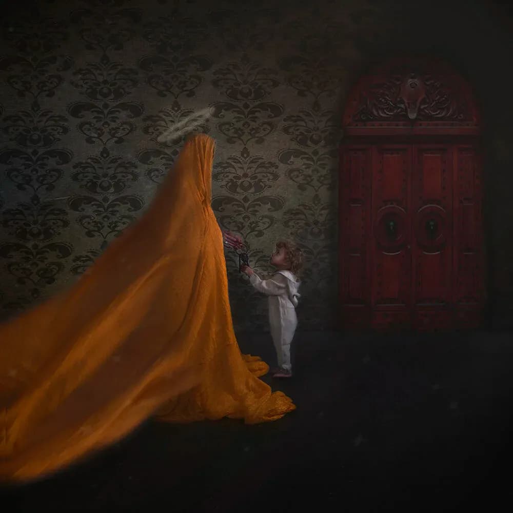 Figure in white dress with large flowing golden-orange fabric, standing before ornate red wooden door against damask wallpaper.