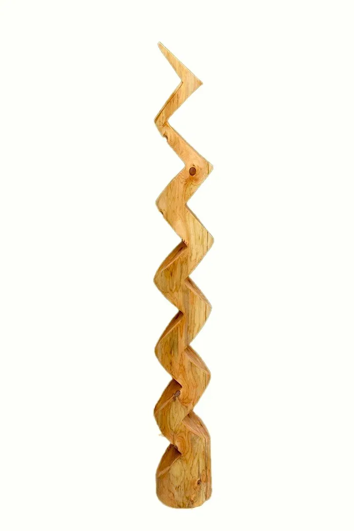 Tall zigzag carved wood sculpture on a raw log base against white background