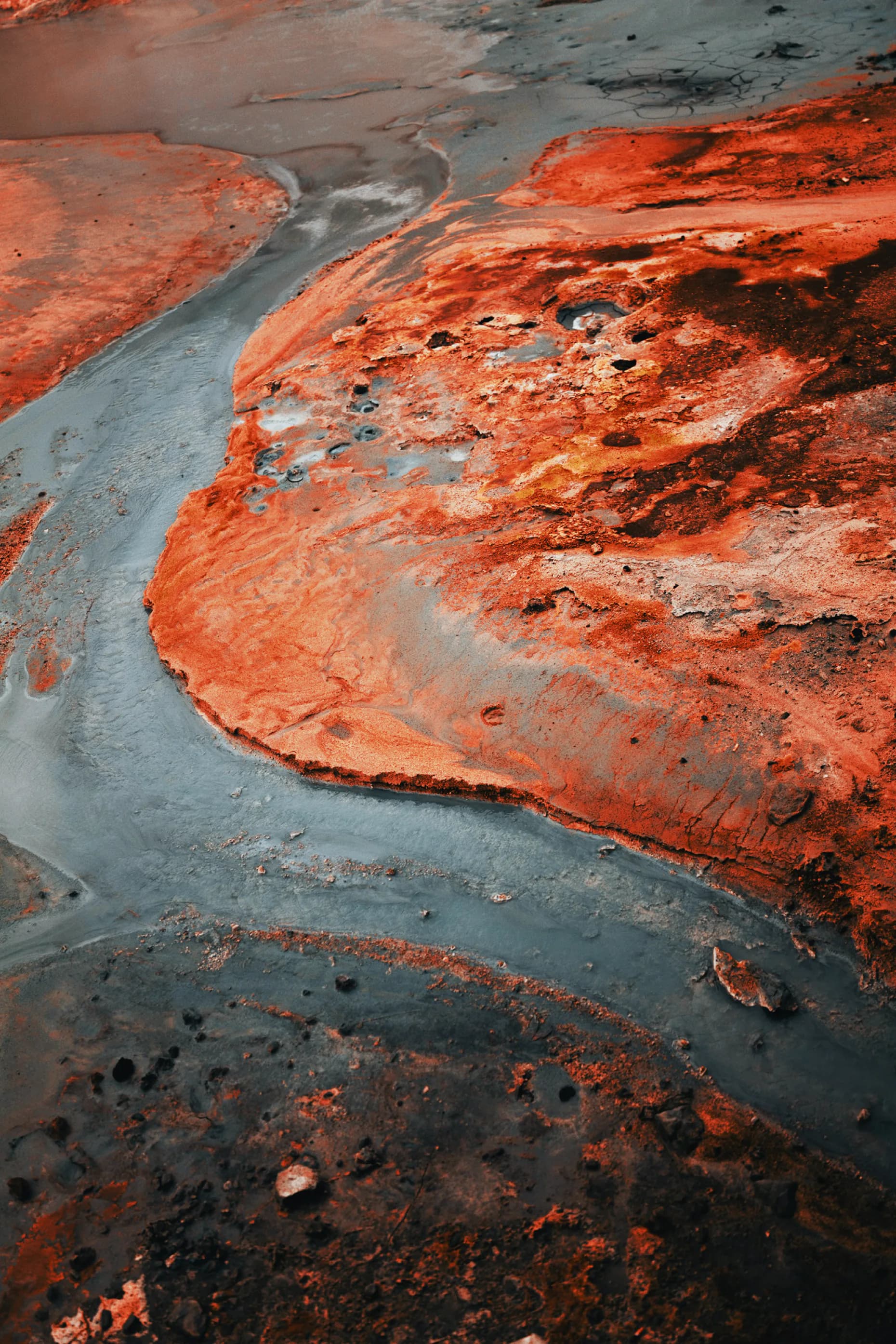 Abstract aerial view of red oxidized mineral landscape with grey water channels