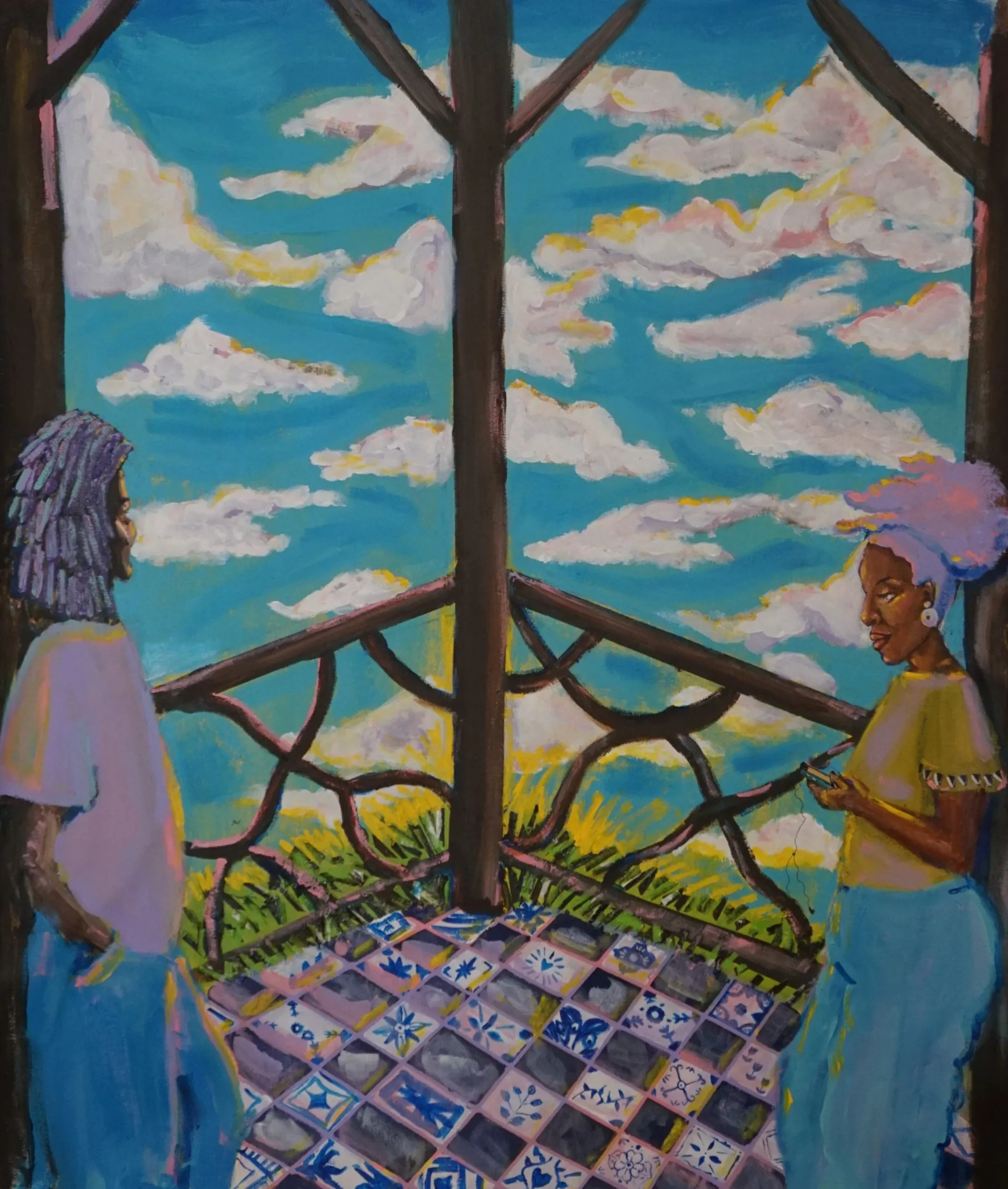 Two Black women on a tiled balcony overlooking a blue sky with clouds