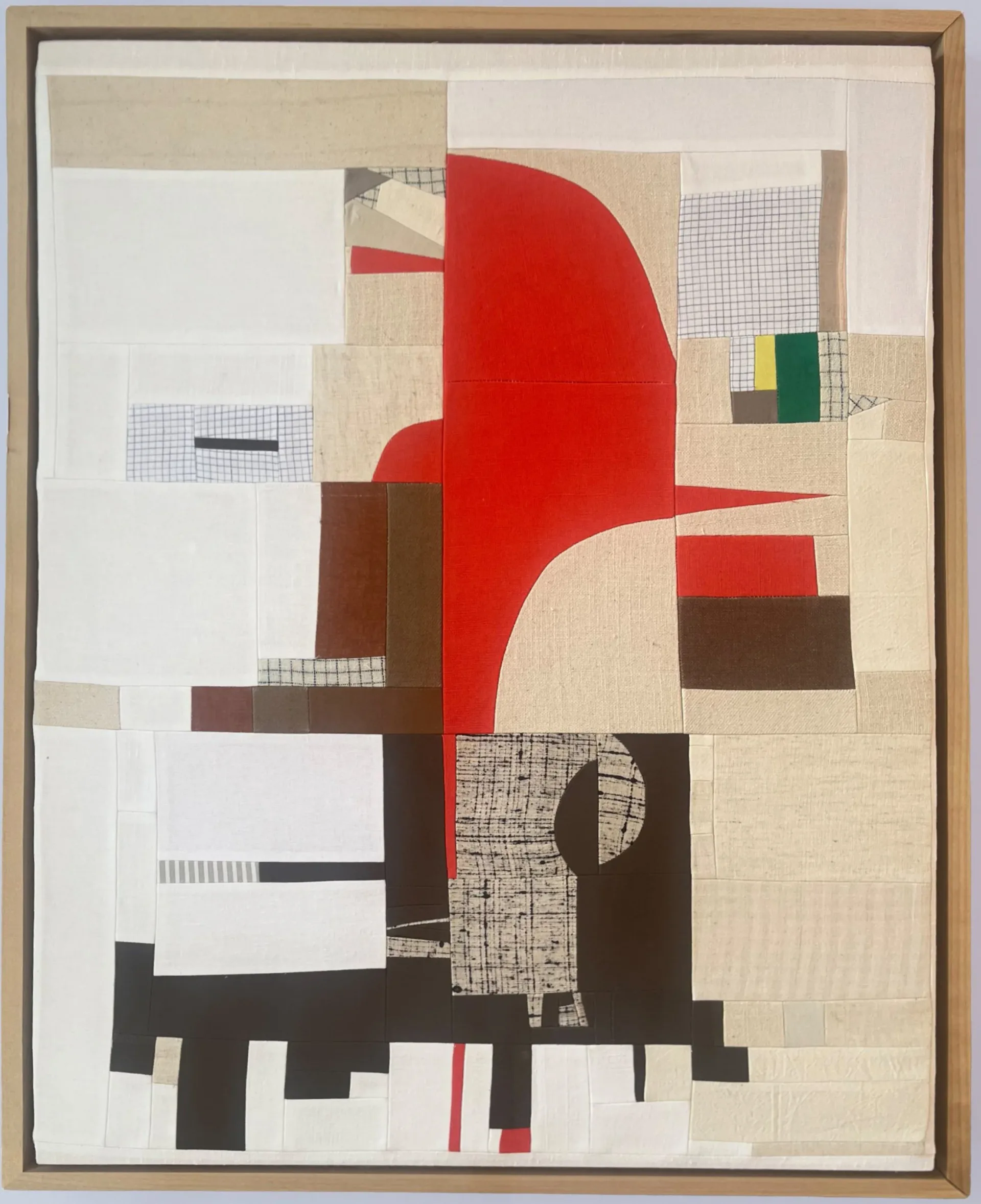Framed abstract patchwork composition combining red curved shape, brown and cream geometric blocks, grid patterns, and mixed fabric textures.