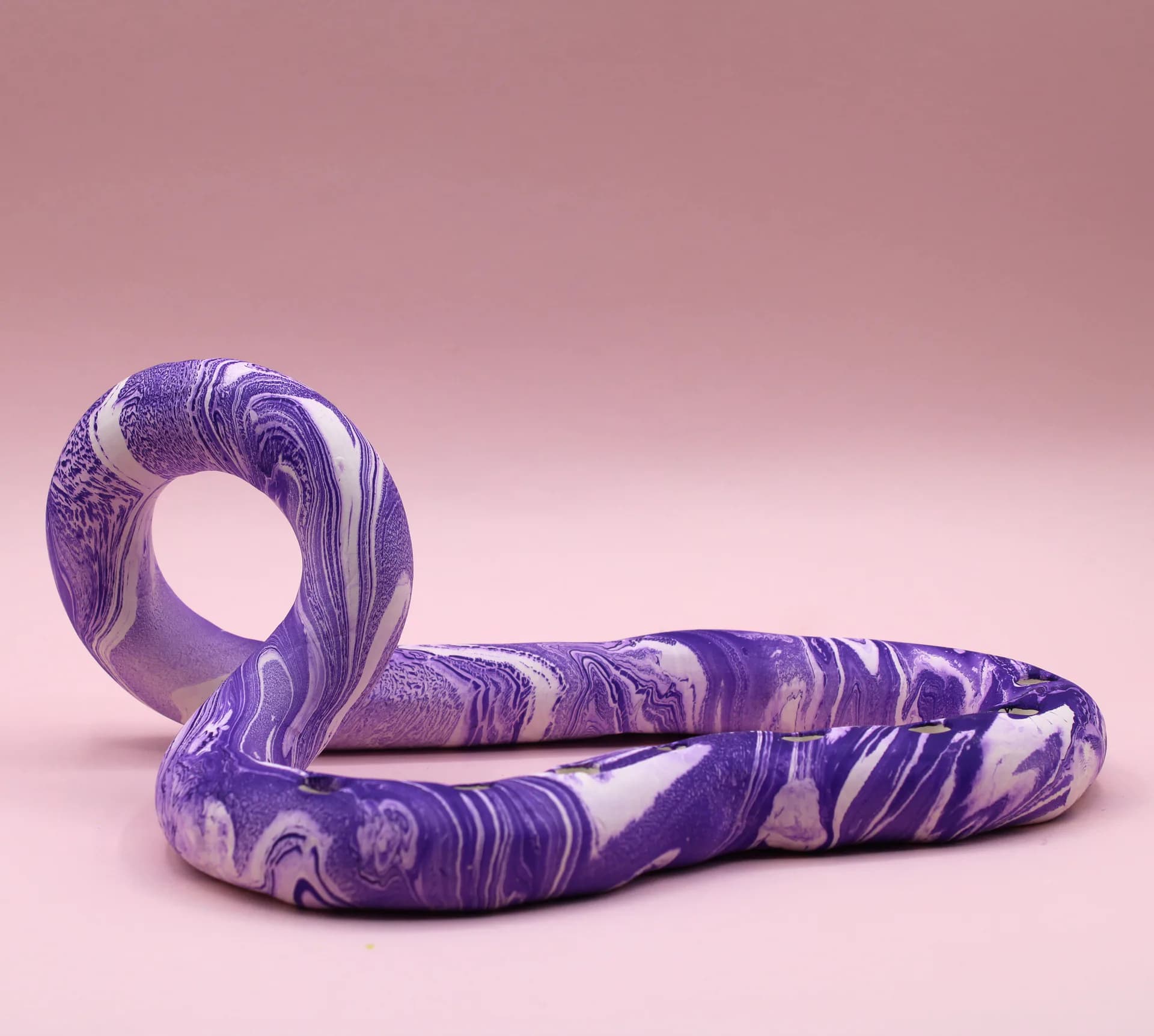 Purple marbled snake-form candelabra with full set of yellow and white beeswax candles, front view