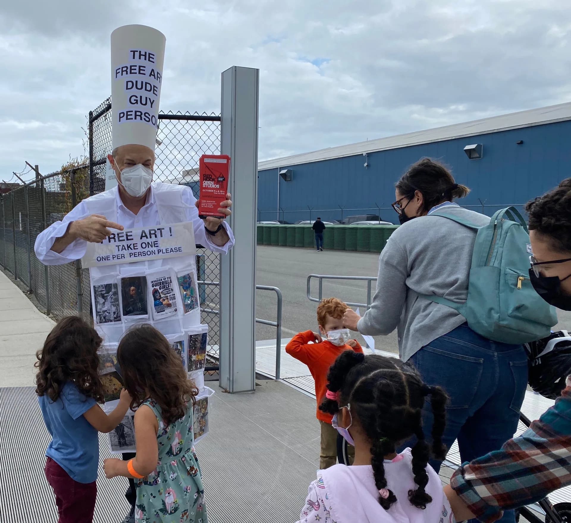 Free Art Dude Guy Person engaging children with free art postcards at outdoor public event