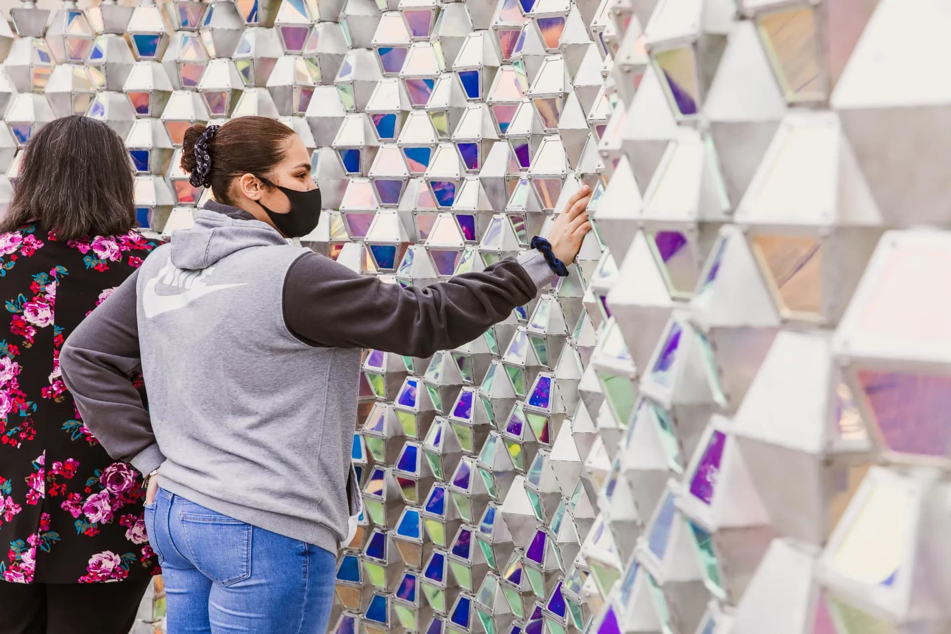 Green concentric arch sculpture by the waterfront at sunset with couple seated inside