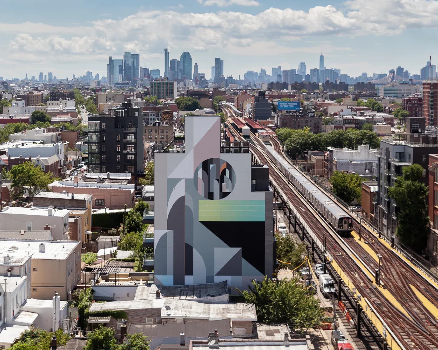 Tall exterior building mural with abstract geometric composition in blacks, whites, and pastel accents overlooking NYC cityscape.