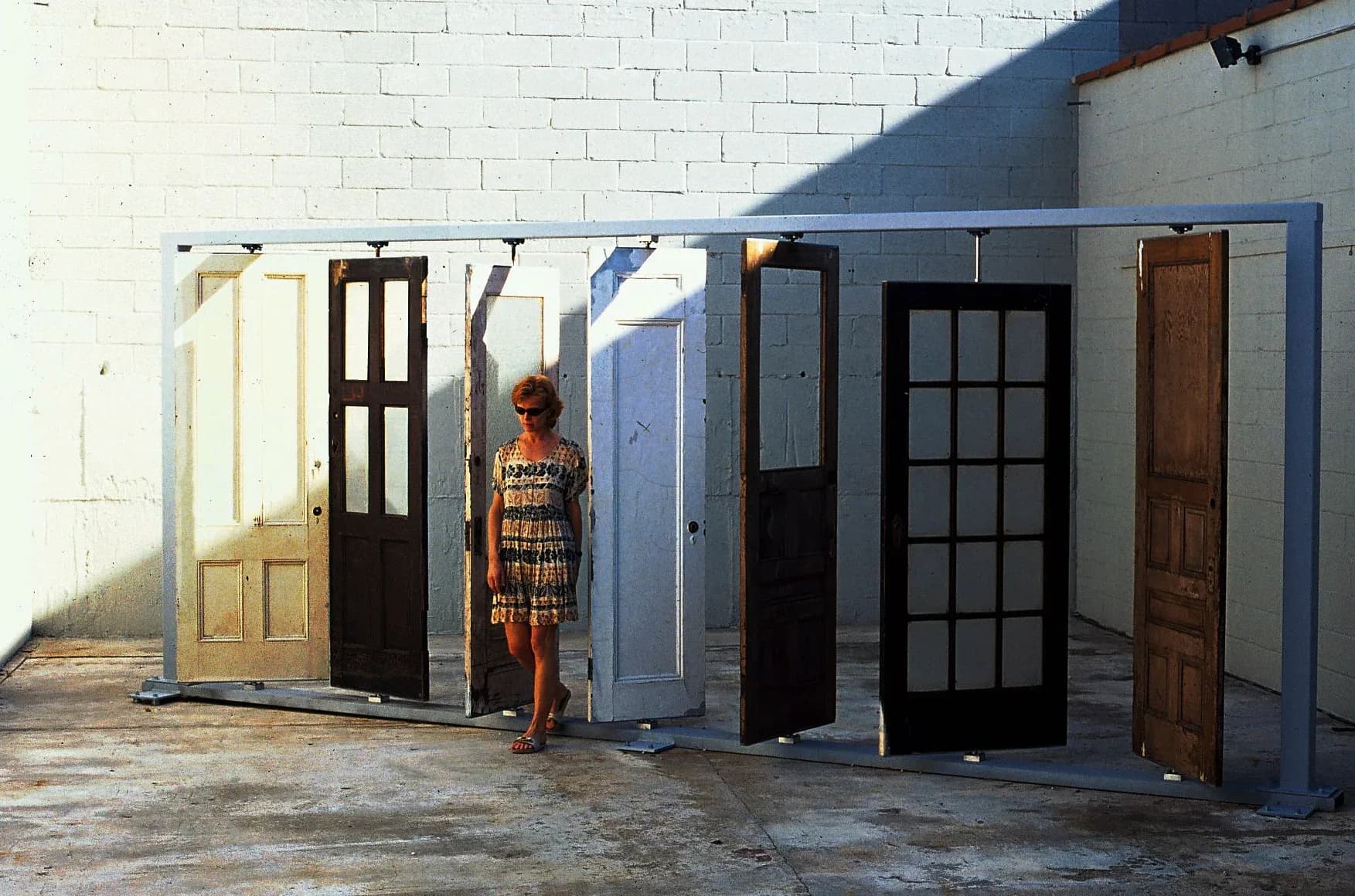 Large-scale installation of multiple salvaged doors mounted on a steel frame outdoors