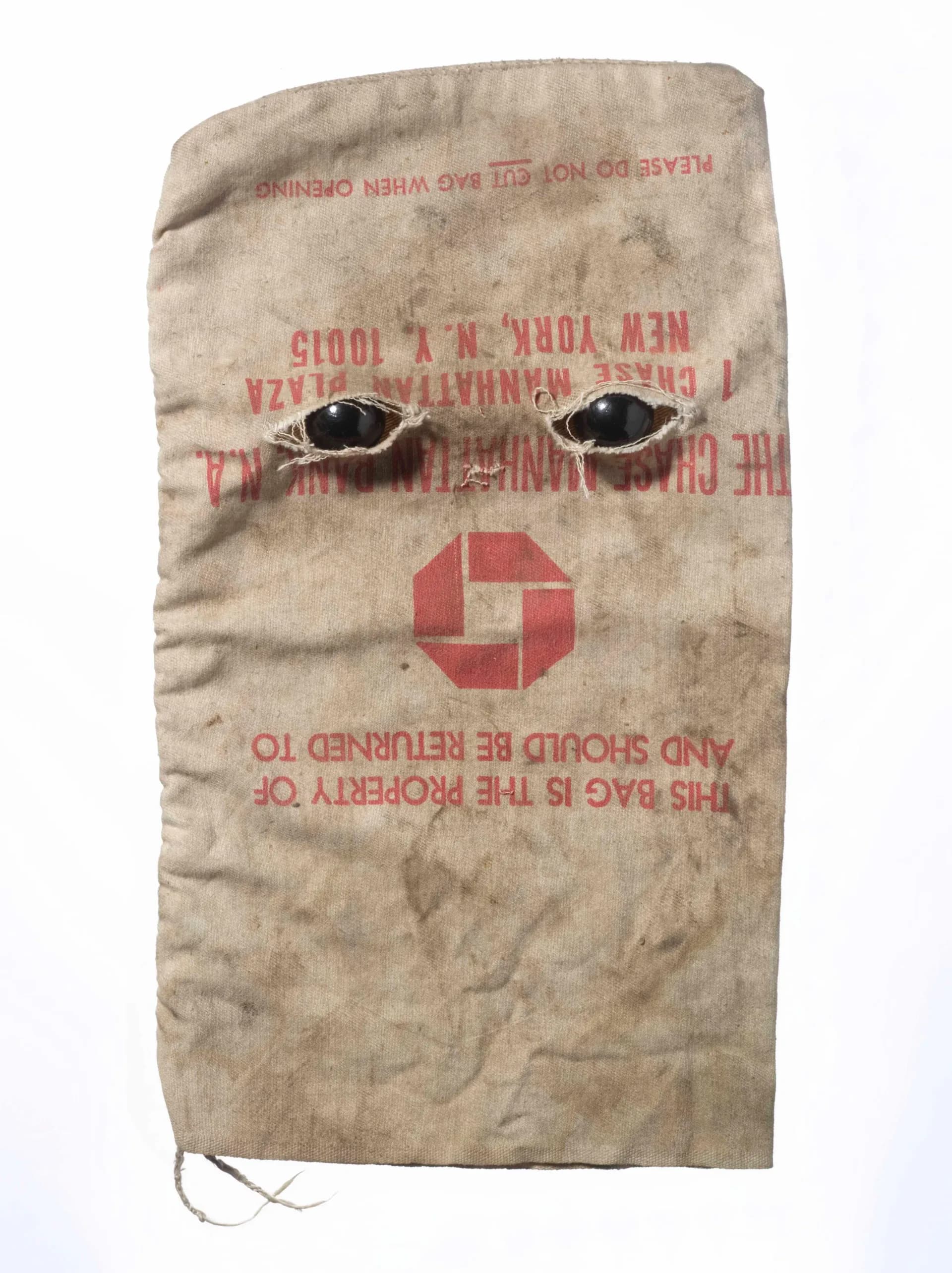 Chase Manhattan Bank canvas money bag with two black glass eyes pierced through the fabric, displayed flat