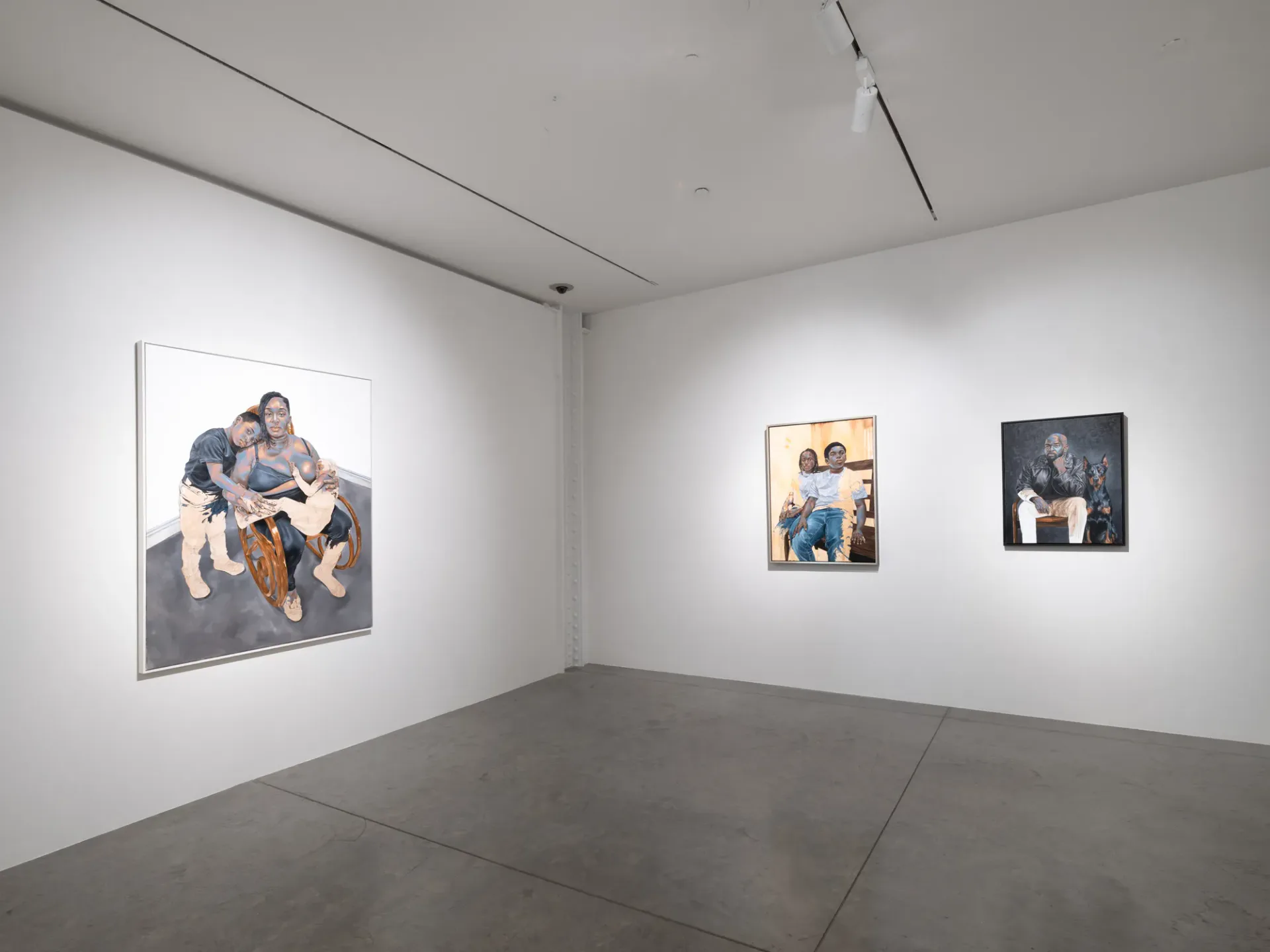 Gallery room with large figurative photograph on left wall and two smaller portrait paintings on right wall.