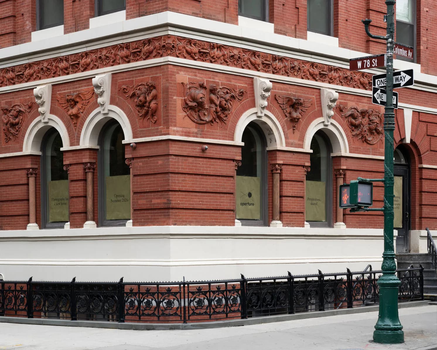 Photograph of an ornate red brick building facade with arched windows, white trim, and decorative carved details.