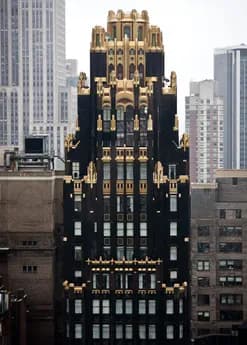 Architectural photograph of the American Radiator Building, a black and gold Art Deco skyscraper with ornate crown detail against Manhattan skyline.