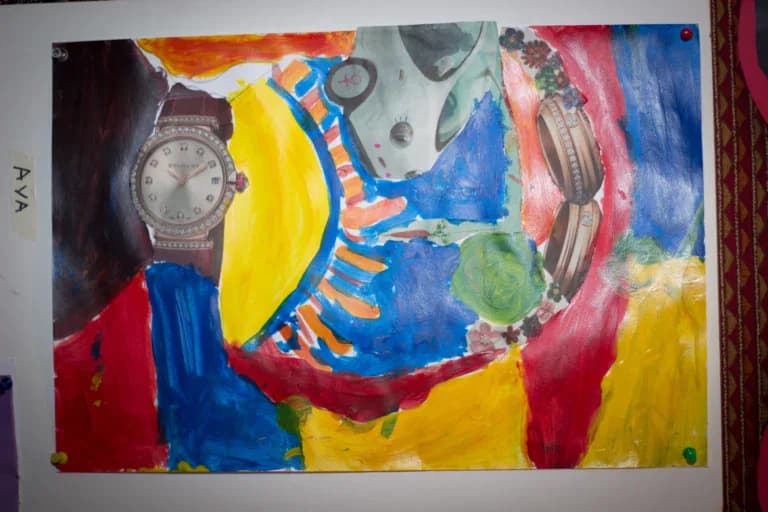 Abstract mixed-media painting on paper with vibrant blue, yellow, red, and green sections, featuring a sun motif and collaged objects including watches.