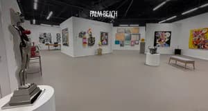 Gallery interior wall displaying multiple framed artworks and pieces with track lighting, labeled "FRAM-REACH" at top.
