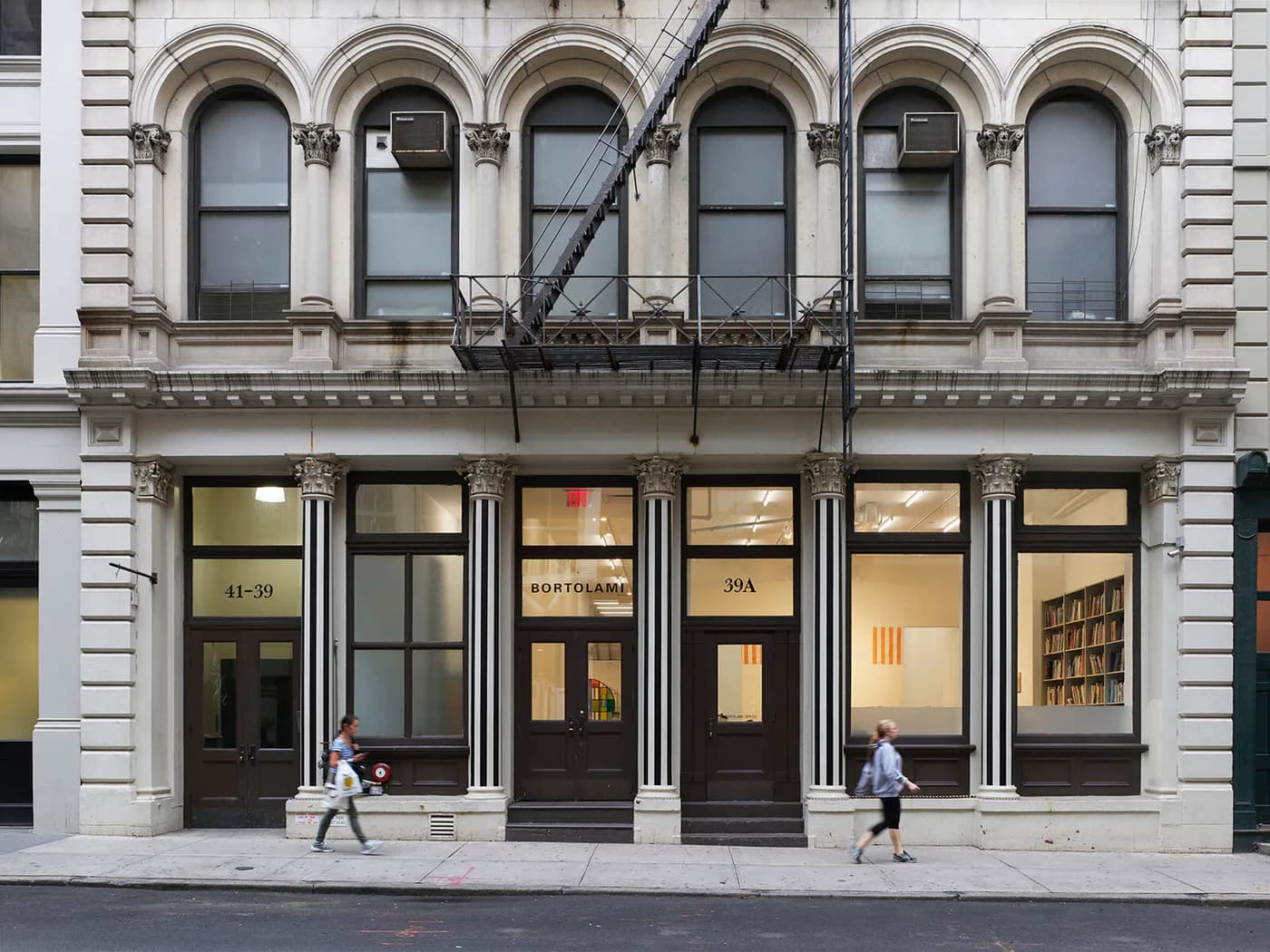 Bortolami gallery storefront in Tribeca with large arched windows and dark entrance doors on ground floor of historic building.