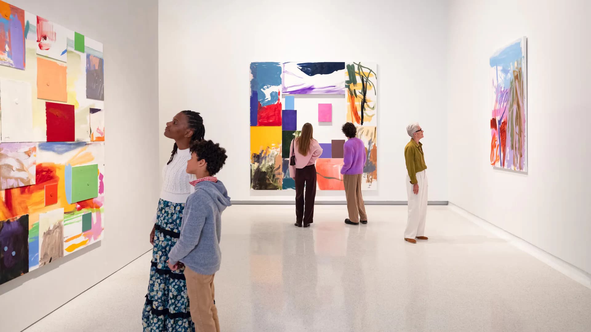 Canada Gallery's white contemporary interior with visitors viewing colorful abstract paintings and mixed-media works on walls.