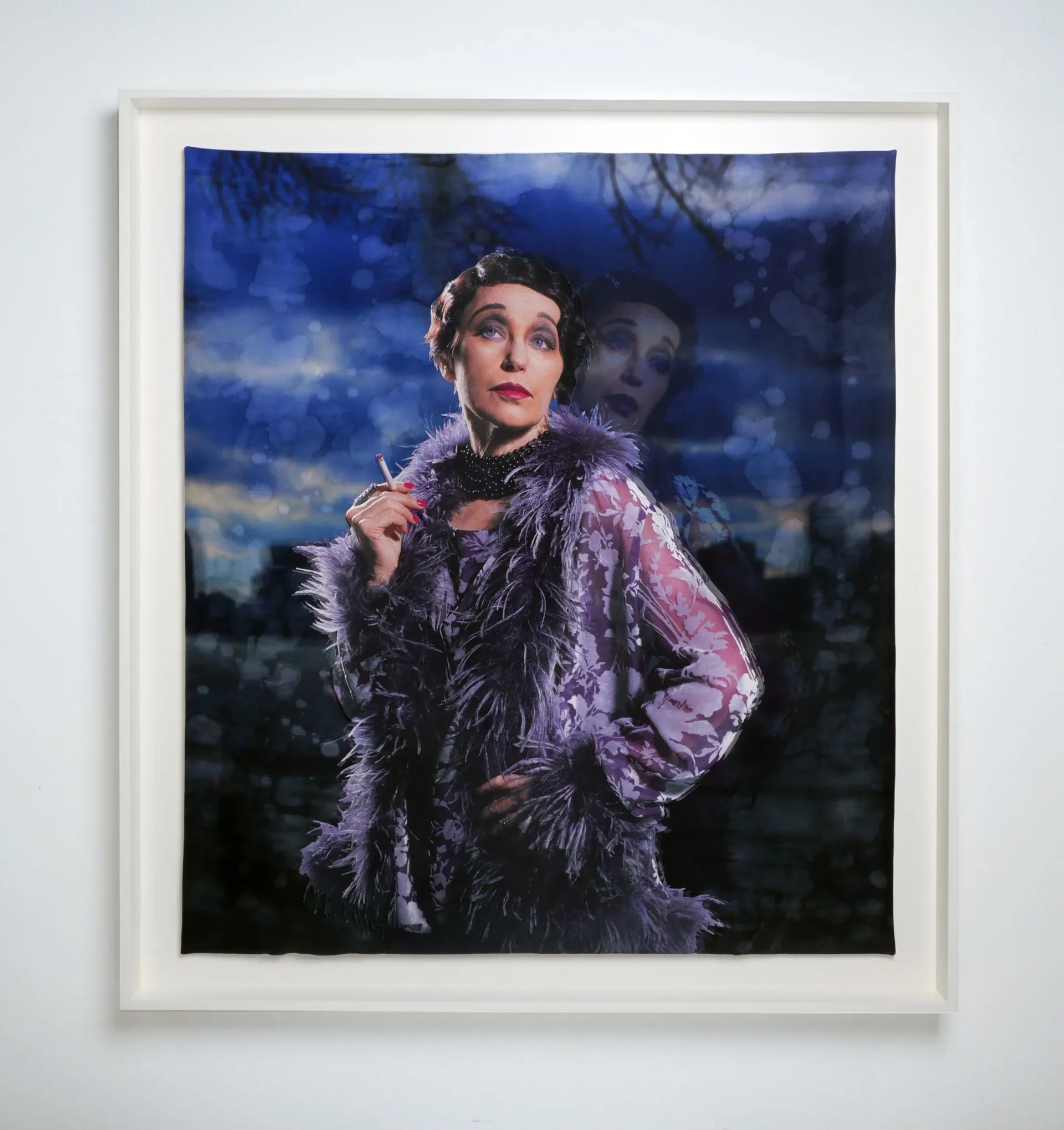 Framed color photograph of a woman in purple sequined jacket and feathered collar against dramatic night sky background.
