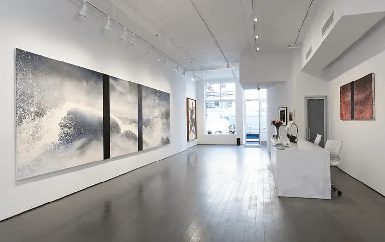Chase Contemporary gallery interior with white walls, polished concrete floor, and large abstract grayscale paintings on the left wall, bright natural light from storefront.