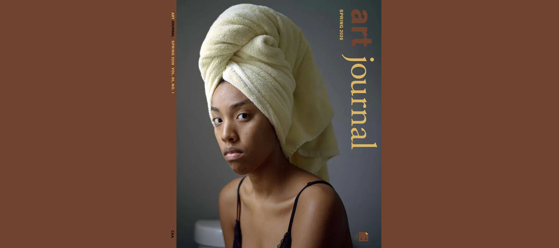 Portrait of a person wearing a cream-colored head wrap against a gray background, with the word 'journal' printed vertically on the right edge.