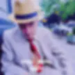 Blurred photograph with blue, green, and red tones; subject indistinct.