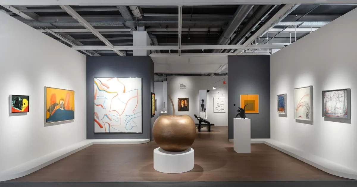 Di Donna Galleries exhibition space with white walls, gray accent wall, central bronze sphere sculpture, and various framed artworks displayed.