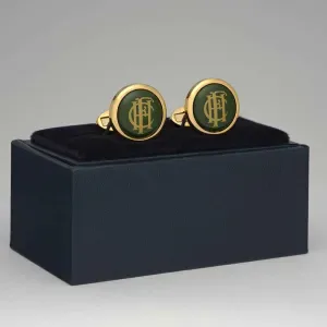 Pair of gold-toned round cufflinks with dark green enamel centers, displayed on a black velvet box.