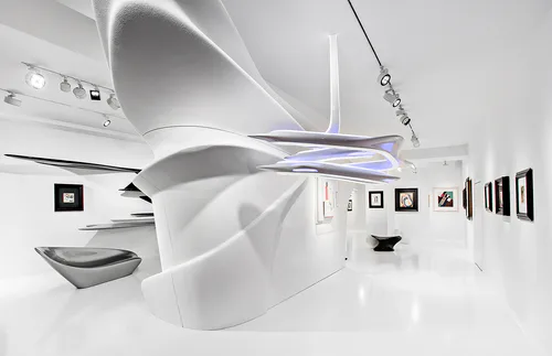 Abstract white sculptural installation with flowing organic forms, mounted photographs on walls, and minimal gallery lighting.