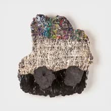 Textile sculpture in cream and multicolor threads with dark charcoal forms at base; organic, cloud-like silhouette.