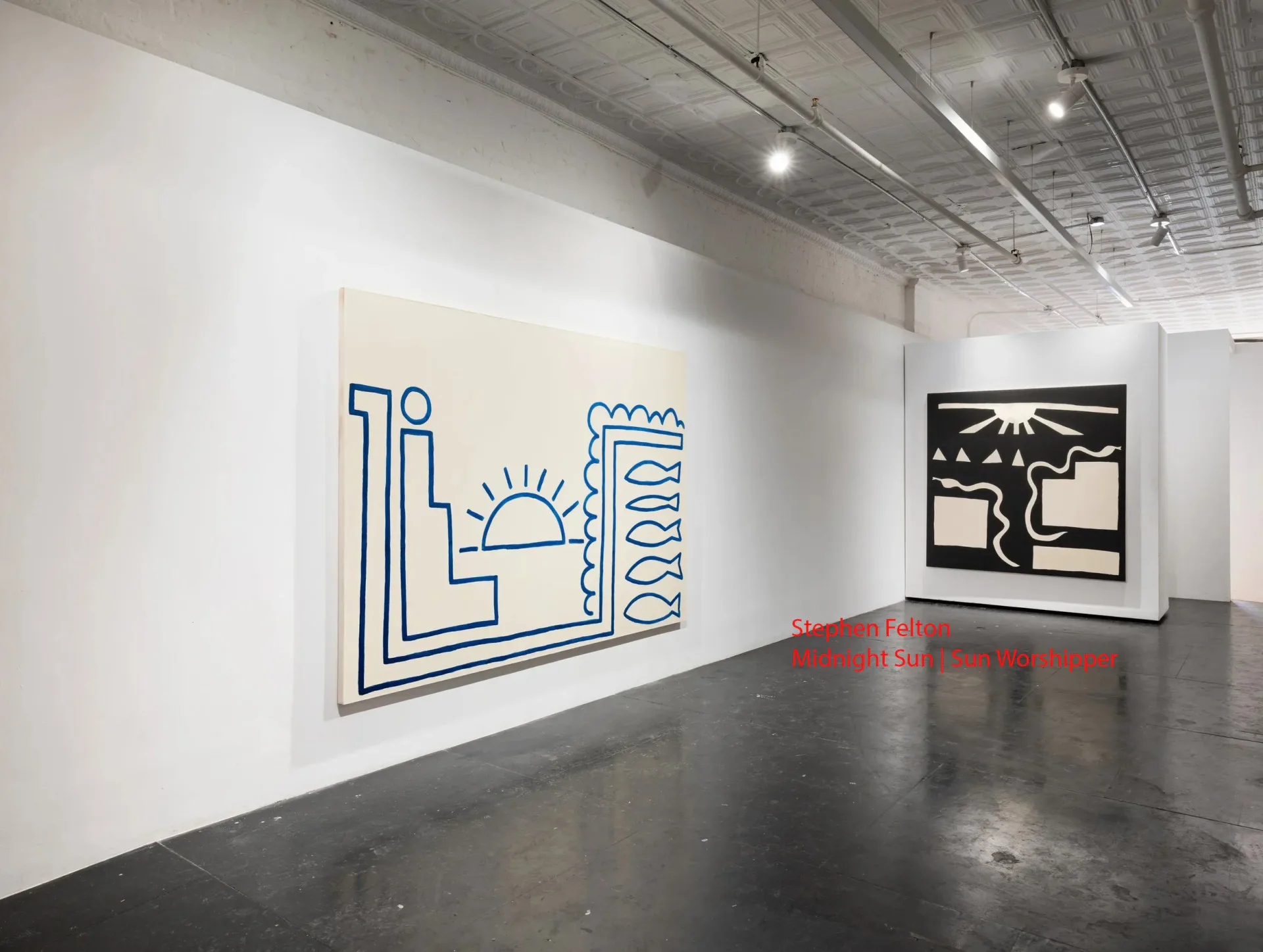 Gallery interior with blue-outlined geometric wall drawing on left and black silhouette artwork on right; polished concrete floor under bright overhead lighting.
