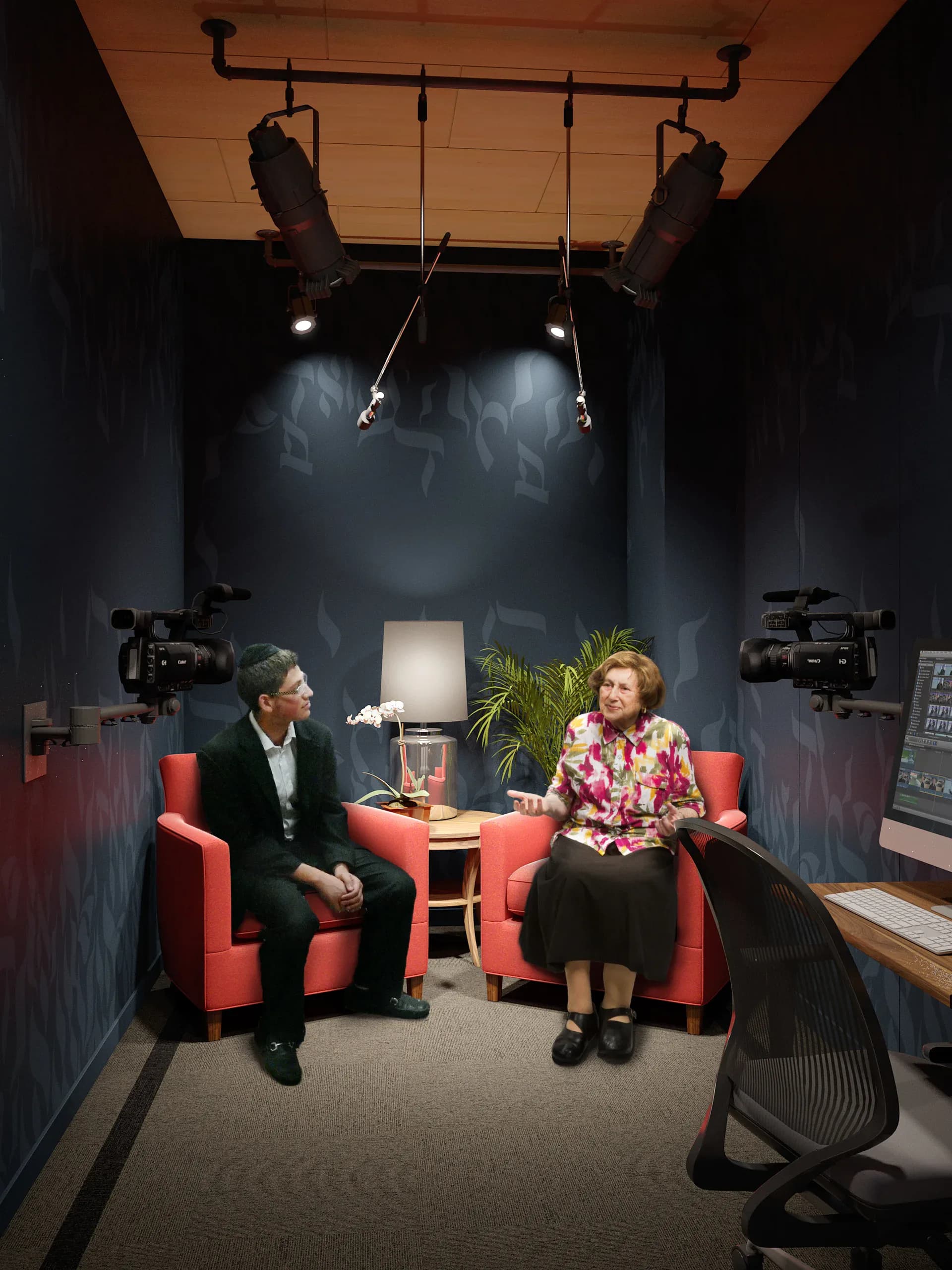 Interview or testimony room with two seated figures facing each other in red chairs, professional lighting rig overhead, and video cameras; Kleinman Holocaust Education Center.